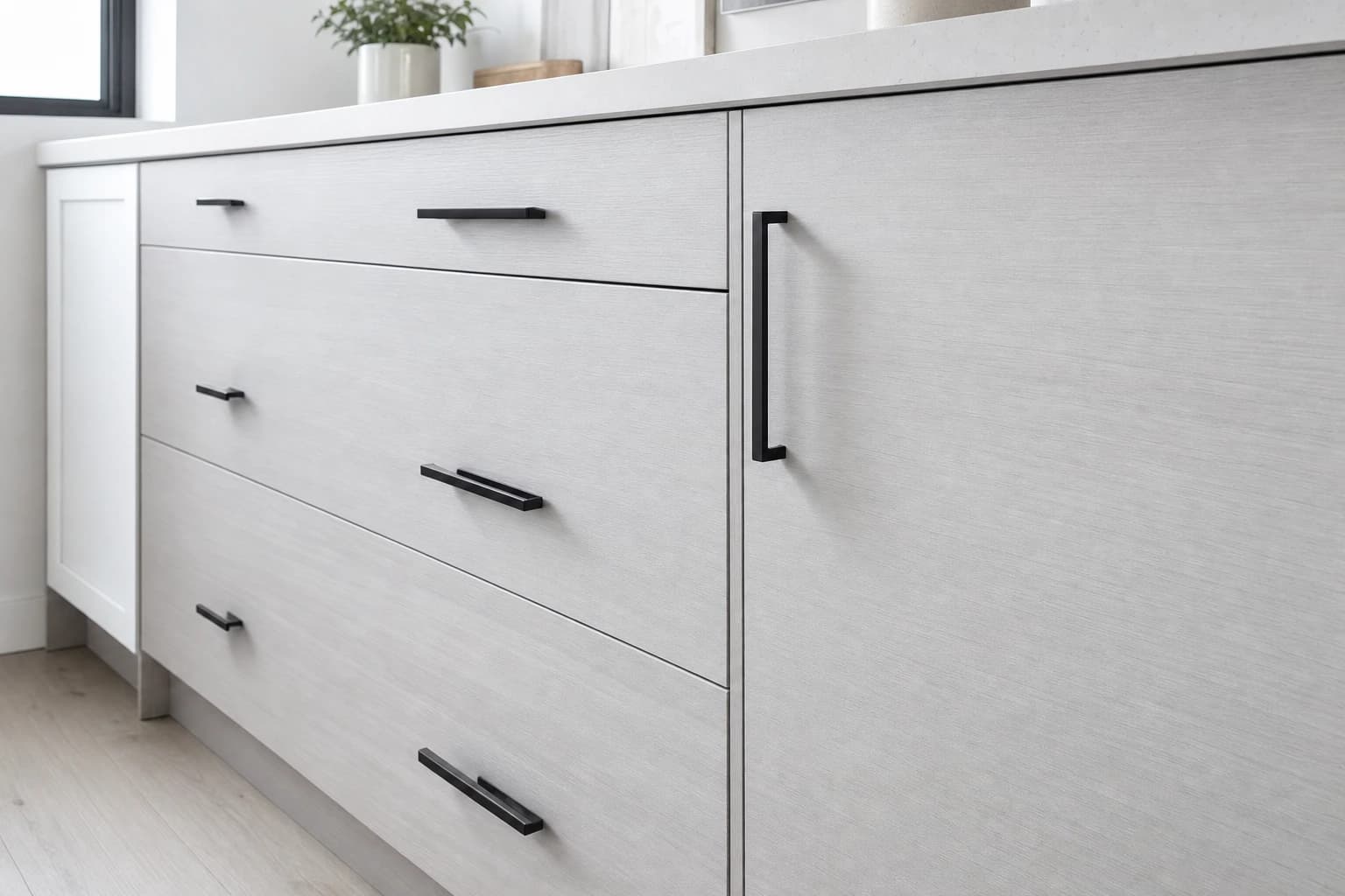 Close-up of grey flat-panel cabinet doors and matte-black pulls in a Sacramento kitchen remodel